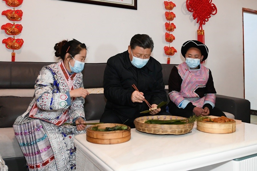 2021年2月3日下午，習(xí)近平在貴州畢節(jié)市黔西縣新仁苗族鄉(xiāng)化屋村苗族村民趙玉學(xué)家，同一家人邊聊家常邊制作當(dāng)?shù)貍鹘y(tǒng)節(jié)日食品黃粑。新華社記者 李學(xué)仁 攝